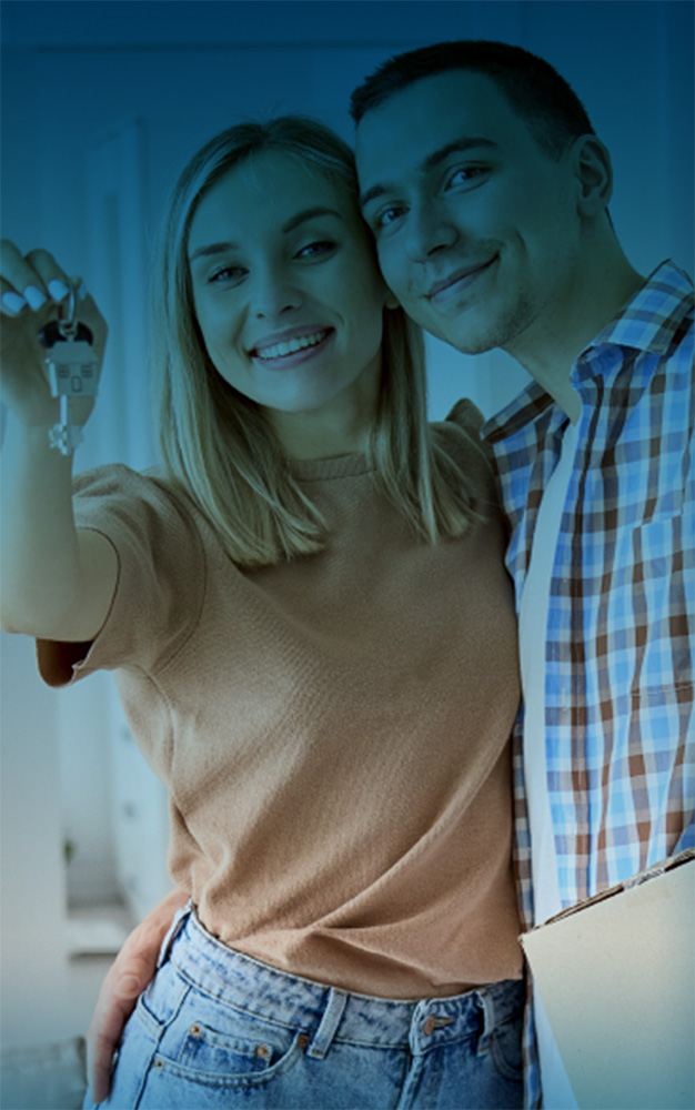 Man and woman smiling holding their new house key